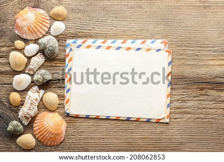 Writing a letter from holiday. Seashells on a wooden background.
