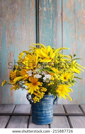 Bouquet of sunflowers and wild flowers on wooden table, copy space