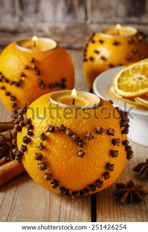 Orange pomander ball with candle decorated with cloves in heart shape