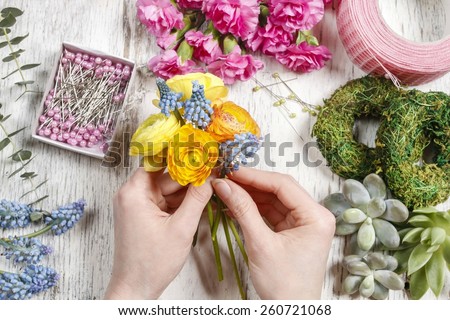 Florist at work. Woman making bouquet of ranunculus flowers