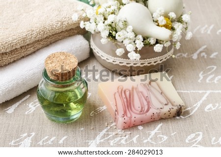 Spa set: bottle of essential oil, soft towels, bar of natural, handmade soap