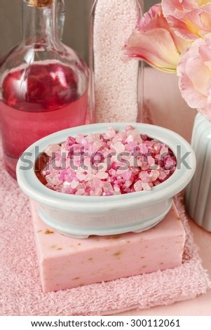 Bowl of pink sea salt, bar of handmade soap and bottle of liquid soap