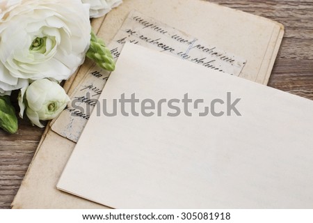 Vintage letters and persian buttercup flowers (ranunculus) on wooden background, copy space