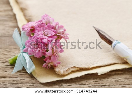 Beautiful tiny bouquet of pink kalanchoe blossfeldiana flowers and vintage letters, copy space