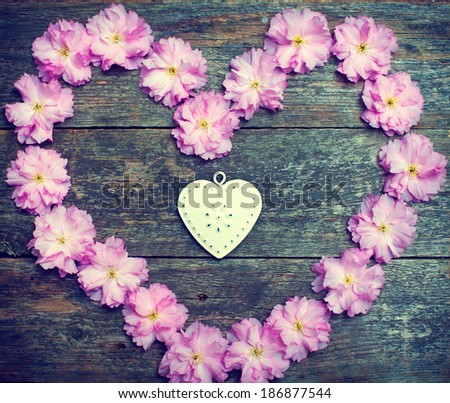 pink flowers and heart on the wooden background.old photo concept