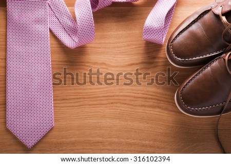 Man's collection:  tie, shoes on a wooden background