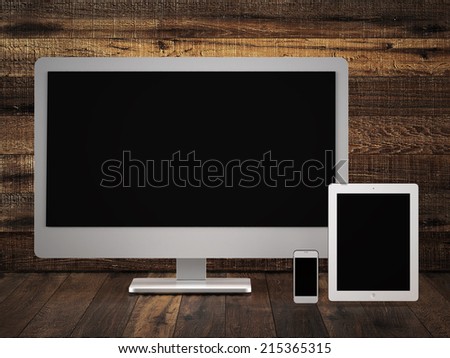 Monitor tablet and phone  on old wood surface