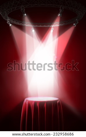 Presentation pedestal covered with red silk cloth on a red background.