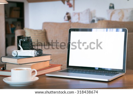 Stack of old books and tablet over wooden table