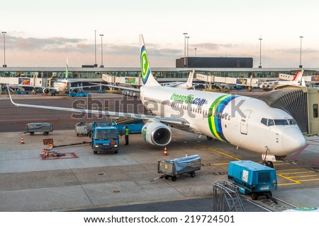 AMSTERDAM, NETHERLANDS - 08 SEPTEMBER 2014 : Transavia airlines boeing 737-700 parked at terminal for loading and maintenance operations before to flight at sunrise . Amsterdam Schiphol airport.