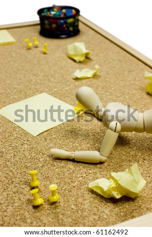 Cork noticeboard with sticky post-it notes, pins and a wooden model dummy doll - office paper work - office paperwork.