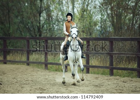 Woman jockey is riding the horse outdoor