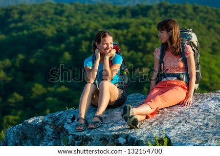 Two trekkers took a rest at the stone in Crimea mountains