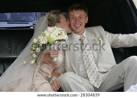 Portrait of the bride  and groom sitting in the car