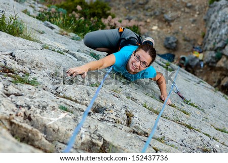 Woman practices in climbing at the rock in the Crimea mountains
