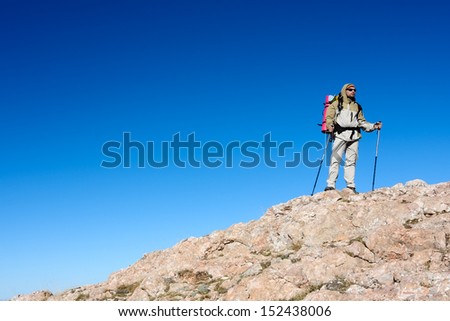 Hiker is standing on top of mountain in Crimea mountains against blue sky