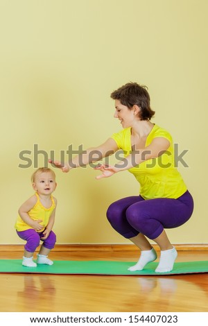 Mother do physical exercises with her daughter at home
