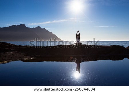 Caucasian woman is doing yoga excercises against picturesque landscapes in Norway