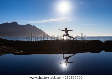 Caucasian woman is doing yoga excercises against picturesque landscapes in Norway
