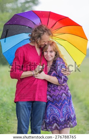 Pregnant couple under an umbrella