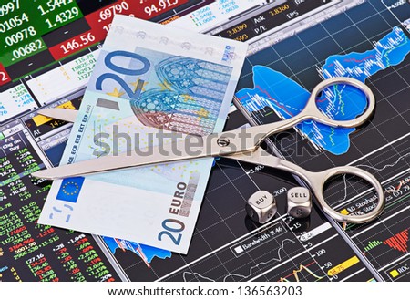 Scissors cutting  euro  banknote, dices cubes with the words SELL BUY. Financial charts and columns of prices as background. Selective focus