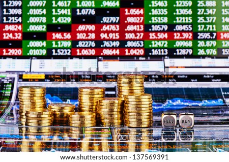 Dices cubes with the words SELL BUY, columns of golden coins and financial charts as background. Selective focus