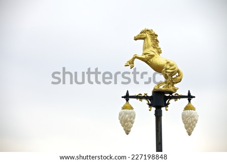 Bronze sculpture of a horse standing on a light pole.