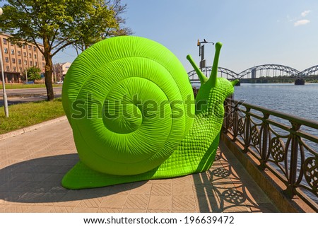 RIGA, LATVIA - MAY 25, 2014: Green snail on the bank of Daugava River. Artwork of Makslai Vajag Telpu organization installed to force the process of constructing a Museum of modern art in Riga