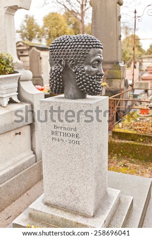 PARIS, FRANCE - FEBRUARY 21, 2015:  Strange two-faced sculpture on the tomb of Bernard Rethore (1949-2011) on Pere Lachaise Cemetery in Paris