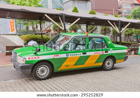 TOKYO, JAPAN - MAY 25, 2015: Green taxi car waiting client near Tokyo Tower in Tokyo, Japan. Green taxies are operated by Tokyo Musen Taxi Cooperation