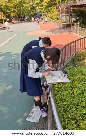 TOKYO, JAPAN - MAY 26, 2015: Japanese school girls paint Wattled Crane from life in Ueno Zoo of Tokyo, Japan