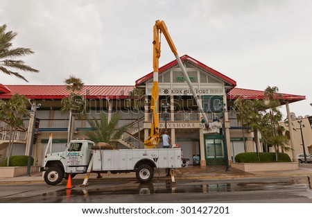 GEORGE TOWN, CAYMAN ISLANDS - JULY 05, 2015: Service company workers washing facade of Bayshore shopping mall using mobile elevating work platform in George Town of Grand Cayman, Cayman Islands