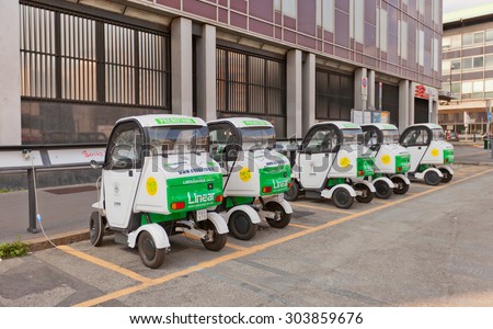 MILAN, ITALY - APRIL 11, 2015: Charging of small two-seater electric automobiles in Milan, Italy