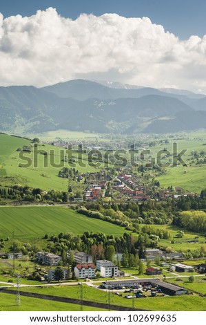 Village in a valley, vertical landscape with some clouds on horizon