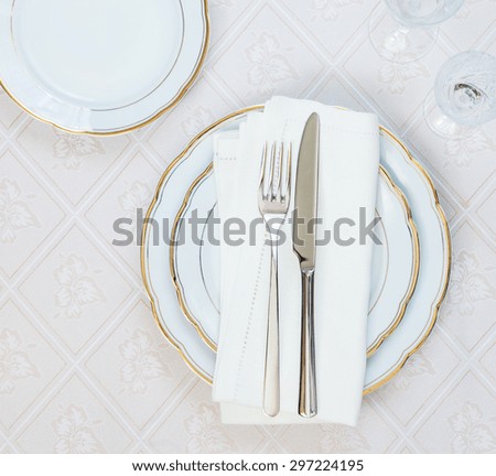 Top view of the beautifully decorated table with white plates, crystal glasses, linen napkin  and cutlery on luxurious tablecloths