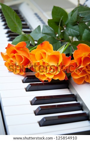 Electronic piano with orange rose flower