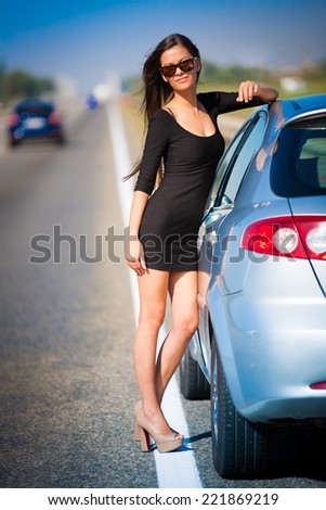 beautiful  brunette  sexy  woman in black dress and sunglasses  has the broken car and  long hair  and elegant body