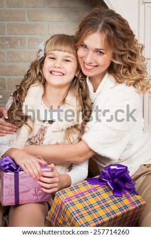 beautiful  smiling  blonde  mother and daughter tree with gifts, mother\'s Day, March 8