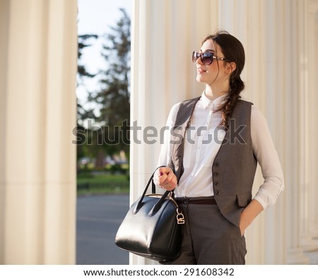 beautiful sensuality elegance lady brunette woman happy face with gray business suit white blouse urban city professional portrait nature lifestyle, background body sunglasses leather handbag pouch
