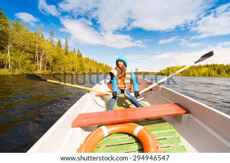 amazing beautiful haired hair woman jeans and jacket orange lifejacket blue lake river water rowing oars sport body way horizon portrait nature day white boat lifebuoy extreme hobby luxury island