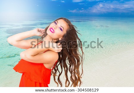 Portrait pretty fun joy sexy smiling brunette woman, has red dress, tan face and  body, pink lips makeup. Sun tropical hot blue sea water resort. Travel rest nature. Amazing lifestyle. Azure sky