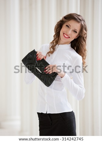 Beautiful sensuality elegance lady brunette woman, has happy face, black business skirt suit, white blouse, leather handbag, slim body. Urban city portrait. Nature lifestyle.