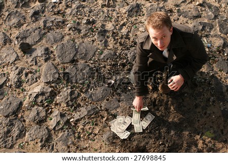 man counting cash lying on the ground