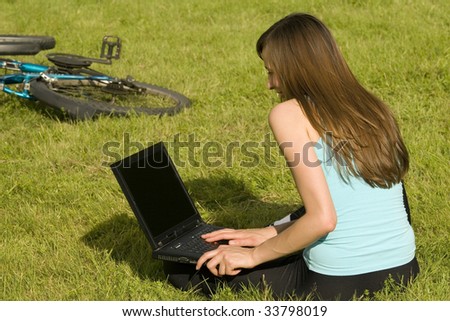 woman with laptop learning on the grass
