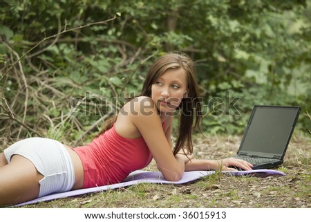 young woman working with laptop in a natural outdoor setting