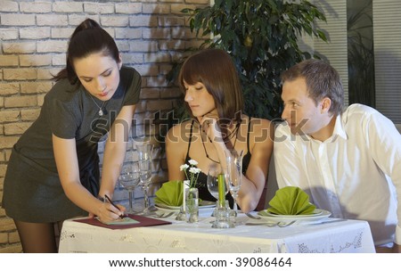 man flirting with waitress during a dinner with his girlfriend