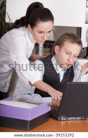 man and woman working on laptop in the office