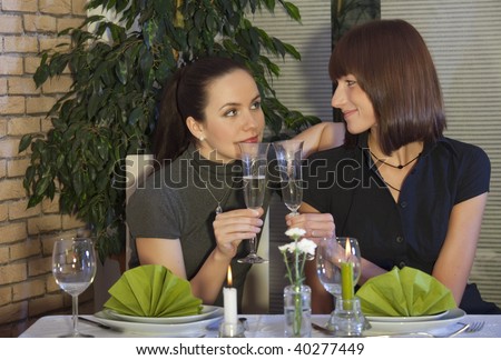 two best friends drinking champagne in a restaurant