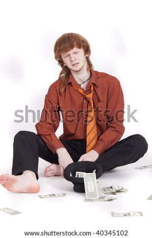crying businessman with hat and money sitting on the ground