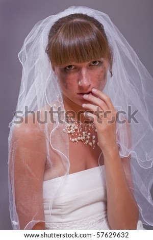 young bride crying on the grey background